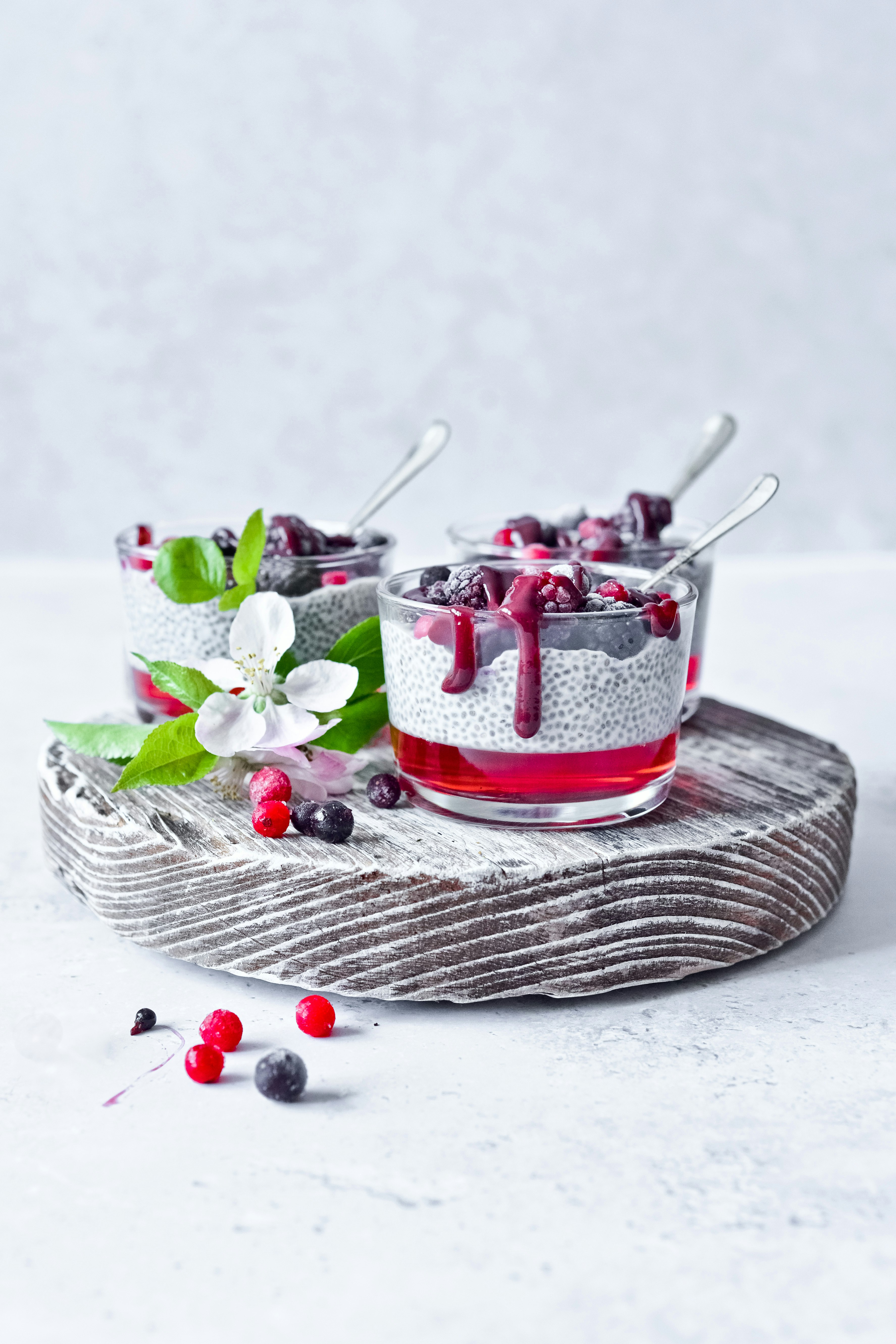 red and white ceramic mug with green leaves on gray round tray